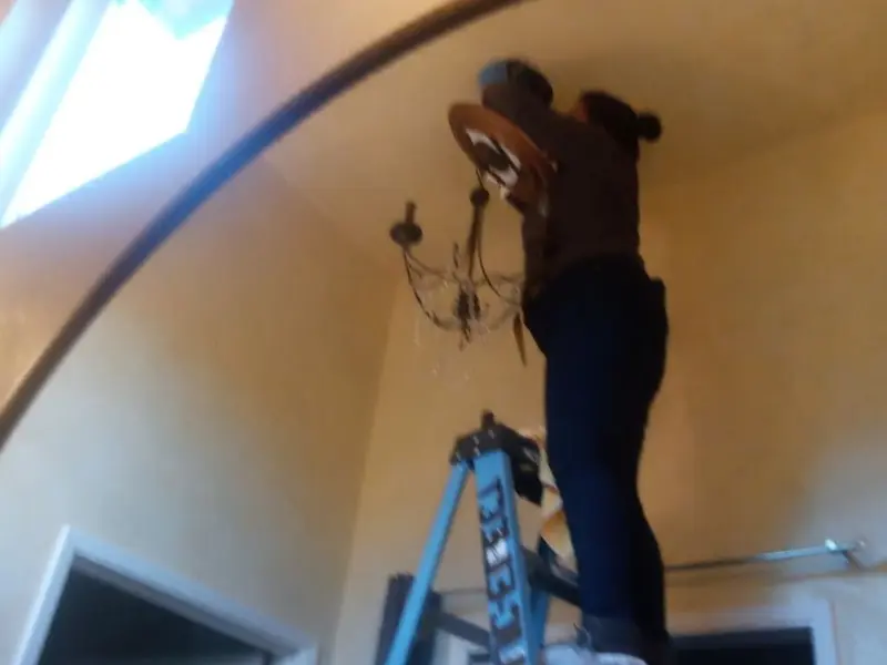 Electrician installing a chandelier in a Olympia Fields residence
